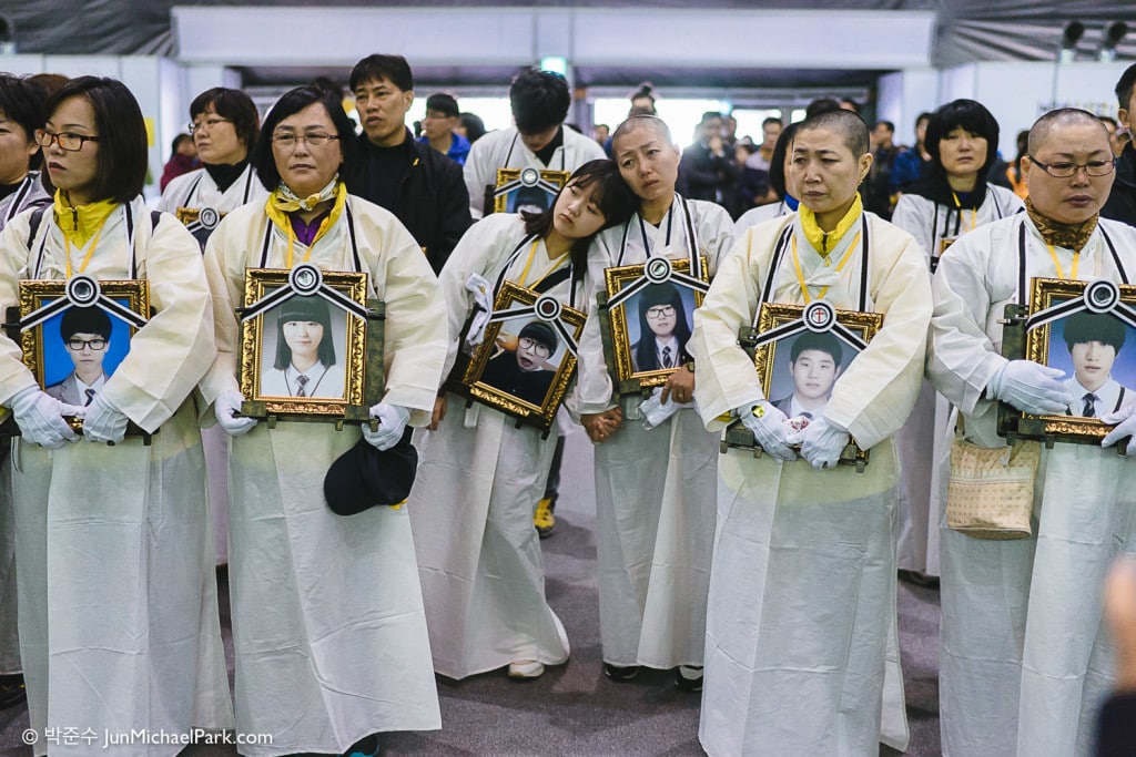 April 2015, just a few weeks before the 1st anniversary, the government proposes the enforcement decree of the Sewol law, which undermines the very independence of the investigative committee. The Sewol families are outraged. Some 70 parents shave their heads in protest, and about 150 parents embark on a 2-day walk protest wearing mourning white dress and holding their children's funerary portraits. A victim's mother and sister lean on each other just before the march began.