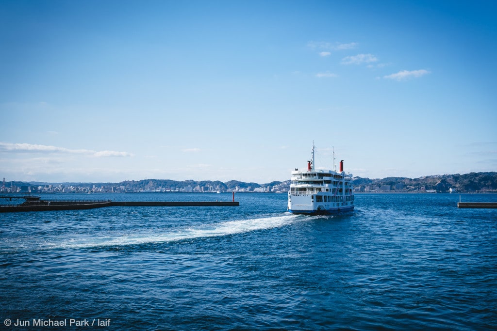 KAGOSHIMA, JAPAN - February 3, 2016: A ferry leaves from the Sakurajima Pier to Kagoshima City. Sakurajima stands for Cheery Blossom Island in Japanese and is known for its active volcano. The lava from the 1914 eruption connected the former island to the Osumi Peninsula. The regular ferry service connecting Sakurajima and Kagoshima City was implemented on November 19, 1934.