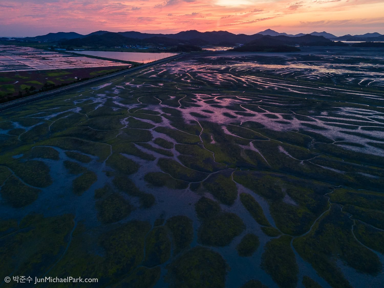 In Jeolla Province, Korea photographer Jun Michael Park captured the sunset, crimson sky, and reflections on mudflats off Jeungdo Island with a drone, resembling tree branches or roots.